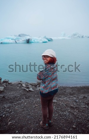 A beautiful woman in front of a glacier in Iceland.