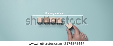Hand putting and array wooden cube stacking for job and technology progress update concept. Royalty-Free Stock Photo #2176895669