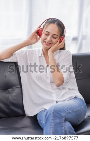 Young beautiful Asian woman girl in casual wear relaxing and listening to music headphones and working indoor
