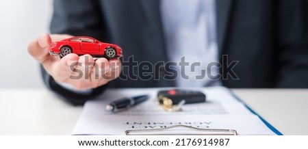 Businessman hand holding red car toy with vehicle keyless, pen and contract document. buy and sale, insurance, rental and contract agreement concepts