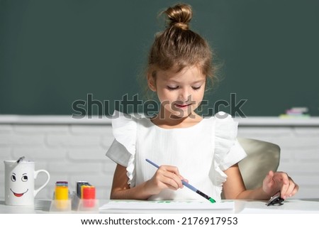 Little girls drawing a colorful pictures with pencil crayons in school classroom. Painting kids. Childhood learning, kids artistics skills.