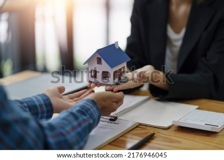 The real estate agent is explaining the home design to interested clients and signing an office sales contract.