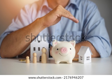 Real estate agent hands over piggy bank for protection and care. Property insurance concept. New home purchase. A loan deal for real estate, A loan agreement for real estate Royalty-Free Stock Photo #2176946207