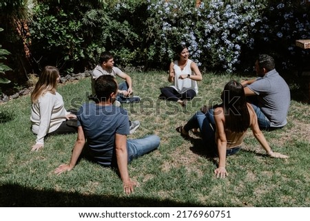 hispanic young people seated in circle on grass and participating at group therapy session in Mexico Latin America Royalty-Free Stock Photo #2176960751