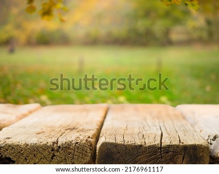 Empty wooden table on the background of picturesque autumn nature. Close-up. There is no one in the photo. Camping, fresh air, family vacation, vacation with friends, picnic.