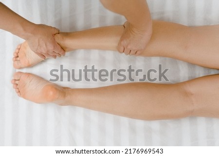 Closeup photo of professional masseur massaging woman's legs in beauty salon