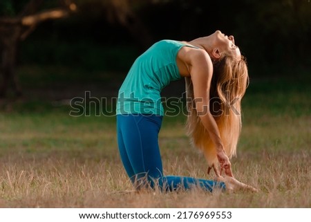 Young blonde woman enjoying nature during stretching exercise