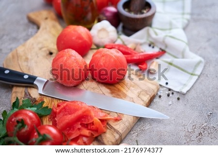 blanched peeled tomatoes on wooden cutting board at domestic kitchen Royalty-Free Stock Photo #2176974377
