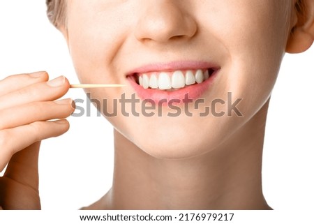 Woman cleaning teeth with bamboo toothpick on white background, closeup Royalty-Free Stock Photo #2176979217