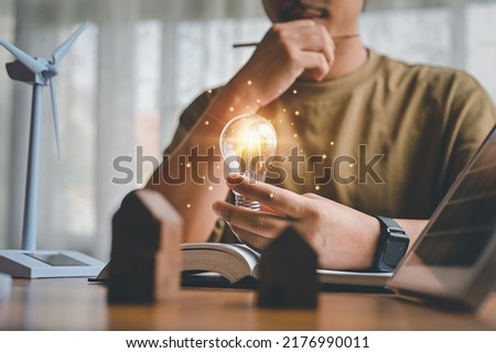 Energy engineers people holding light bulbs while thinking. Innovative concept, thinking of natural energy engineering in design, Knowledge in education, inspiration and imagination in technology. Royalty-Free Stock Photo #2176990011