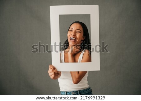 Laughing smiling close up of multiethnic female holding a frame 