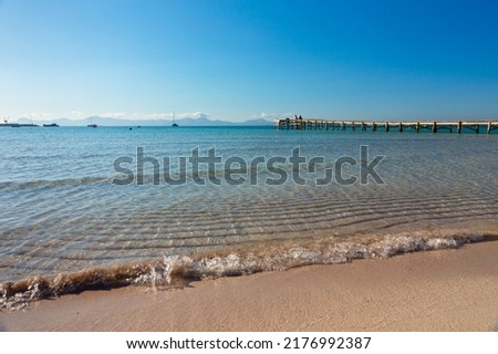 Alcudia beach, in Mallorca.Crystal clear and turquoise waters in a large sandy area with a boardwalk. Royalty-Free Stock Photo #2176992387