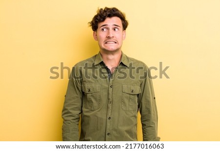 young handsome man looking worried, stressed, anxious and scared, panicking and clenching teeth Royalty-Free Stock Photo #2177016063