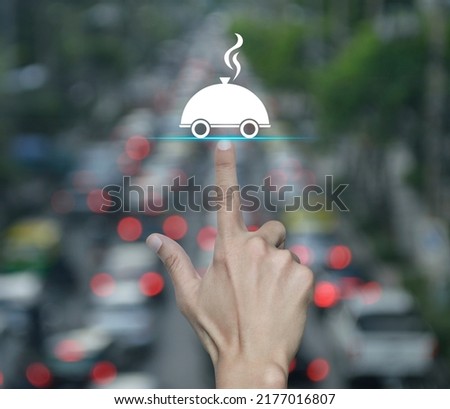 Hand pressing restaurant cloche flat icon over blur of rush hour with cars and road in city, Business food delivery online concept