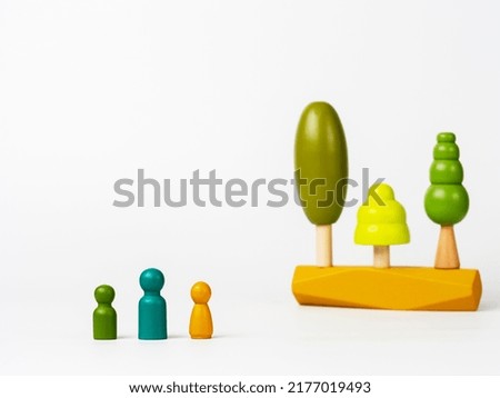 Figures of men with colorful wooden trees in the background. Concept of ecology, respect for nature. The concept of family