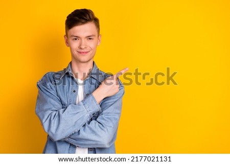 Photo of young man indicate finger empty space promo recommend discount isolated over yellow color background