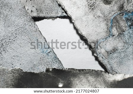 Empty space for logo. Dirty paper background. Distressed frame. Black blue paint grain stains on white worn ripped edge abstract art texture with blank center block for text.