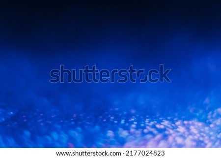 Bokeh light background. Blur neon glow. Sci-Fi radiance. Defocused fluorescent navy blue pink color circles flare on dark presentation abstract texture with copy space.