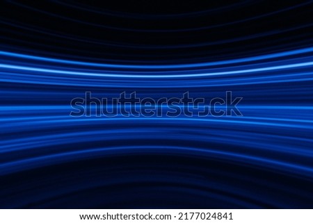 Blur glowing lines. Neon abstract background. Futuristic radiance. Defocused luminous navy blue color curve streak light flare motion on dark black. Royalty-Free Stock Photo #2177024841