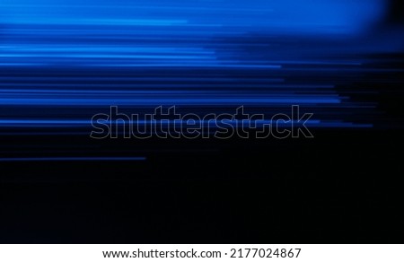 Blur neon rays. Luminous glow. Futuristic radiance. Defocused LED navy blue color lines light flare motion on dark black modern abstract copy space background.