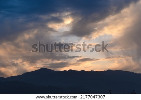 Scenery of clouds and mountain valley after rainfall during sunset.