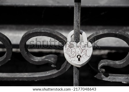 White heart shaped padlock hanging on a metal fence, symbol of love in the park, padlock concept Love forever, Valentine's day, sign of strong love for newlyweds