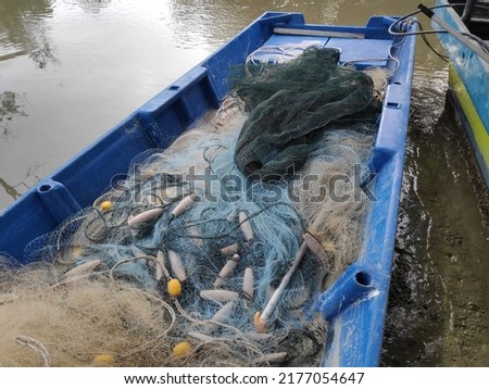 

The picture shows a fishing net used by Malaysian fishermen. fishing boats anchored at the jetty,