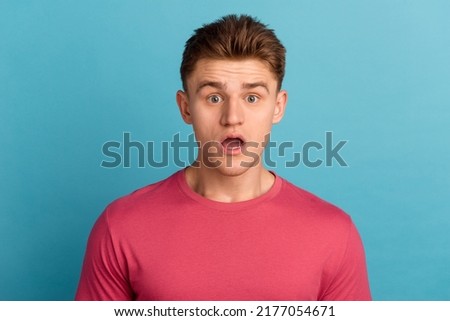Photo of young astonished man fake novelty news stupor panic wow reaction isolated over blue color background