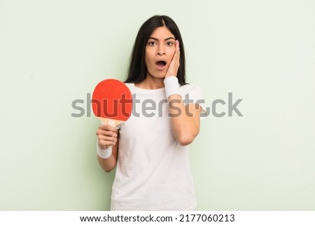 young pretty hispanic woman feeling shocked and scared. ping pong concept