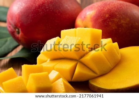 Mango. Close up of fresh ripe mango fruit with leaves over dark wooden table background with green leaves. Royalty-Free Stock Photo #2177061941