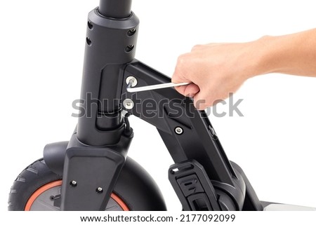 Hand repairing electrical scooter on white background. Special workshop for repairing electrical escooters. Royalty-Free Stock Photo #2177092099
