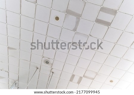 Fluorescent lamps on the modern ceiling. Luminous ceiling of square tiles. Interior idea concept.