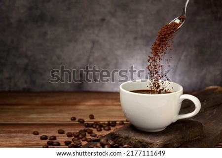 pouring coffee powder on coffee cup on grey background Royalty-Free Stock Photo #2177111649