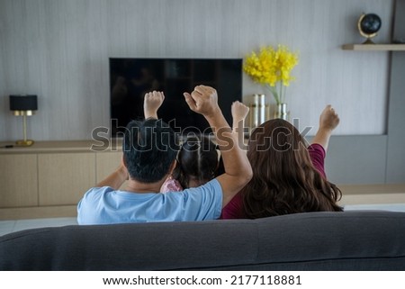 Family watching flat tv at modern home,Happy family having fun time.