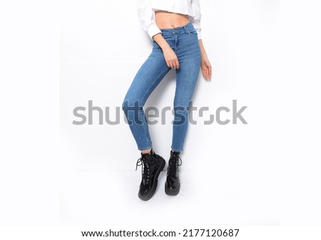 closeup of lower half body woman in black shoes and jeans.

