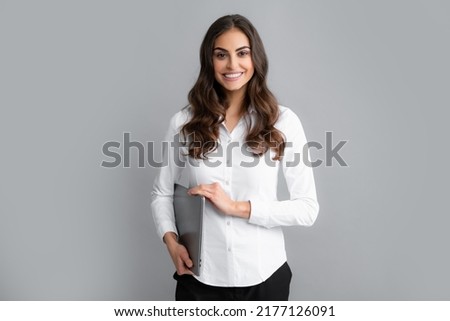 Portrait of young businesswoman using laptop computer isolated on gray background. Business women with laptop. Portrait of business lady holding notebook. Royalty-Free Stock Photo #2177126091