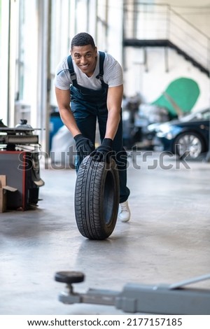 Cheerful young man working in the auto repair shop Royalty-Free Stock Photo #2177157185