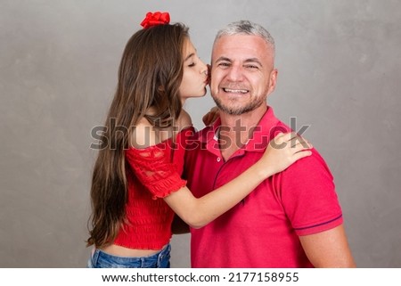 Little girl kissing her father on the cheek, happy father. Side view, selective focus.