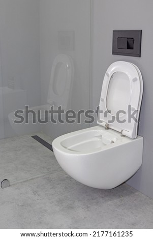 Wall Mounted Toilet Seat With Open Lid in Grey Bathroom Royalty-Free Stock Photo #2177161235