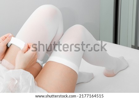 Anti-embolic Compression Hosiery for surgery isolated on white. Medical white stockings, tights for varicose veins and venouse therapy. Thrombo embolic deterrent hose or anti-embolism stockings.