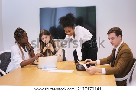 Business people discussing the charts and graphs showing the results of their successful teamwork, multi ethnic business