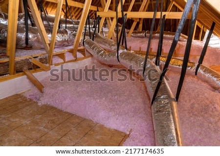 Eco wool insulation is poured in the attic insulation roof for new home Royalty-Free Stock Photo #2177174635