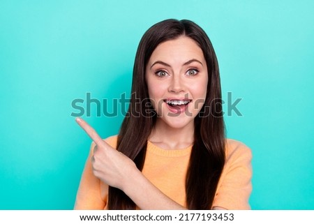 Portrait of cheerful pretty lady indicate finger empty space proposition blank isolated on turquoise color background