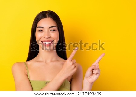 Photo of pretty cheerful filipino person indicate fingers empty space isolated on yellow color background