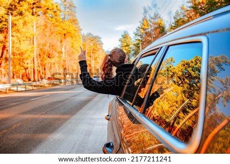 Pretty young brunette woman travelling by car late autumn on the mountains road. Copy space. Travel concept Royalty-Free Stock Photo #2177211241