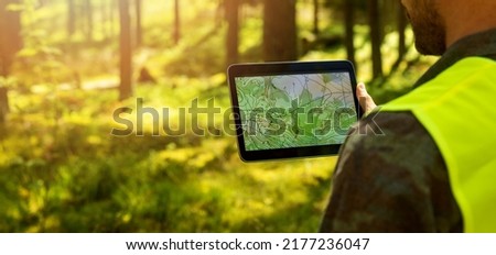 man working with topographic map data on digital tablet in forest. banner with copy space Royalty-Free Stock Photo #2177236047