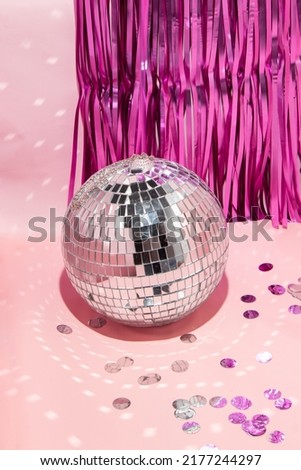 Shiny disco ball, courtain and confetti on pastel light pink background. Trendy party symbols concept. Minimalistic celebration composition. Royalty-Free Stock Photo #2177244297