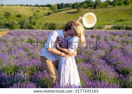 couple in white outfit in lavender field, photo session. man is proposing to woman with ring. engagement day. romance and true love in relationship