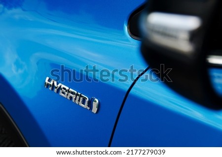 Hybrid emblem on the hybrid blue car Royalty-Free Stock Photo #2177279039
