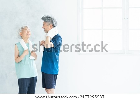 Asian sporty senior couple in the room Royalty-Free Stock Photo #2177295537